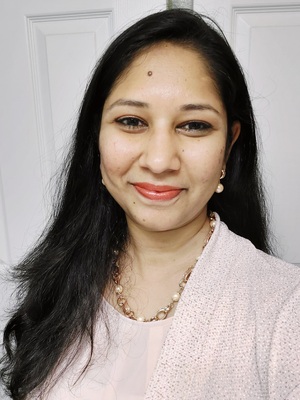 Dr Riti Sharan smiling, wearing a pink blouse