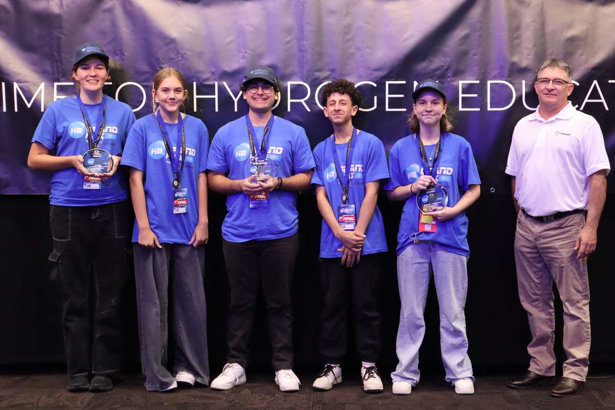 Hydrogen Grand Prix first-place winners stand with their medals and trophies with a stakeholder/sponsor from Stanwell