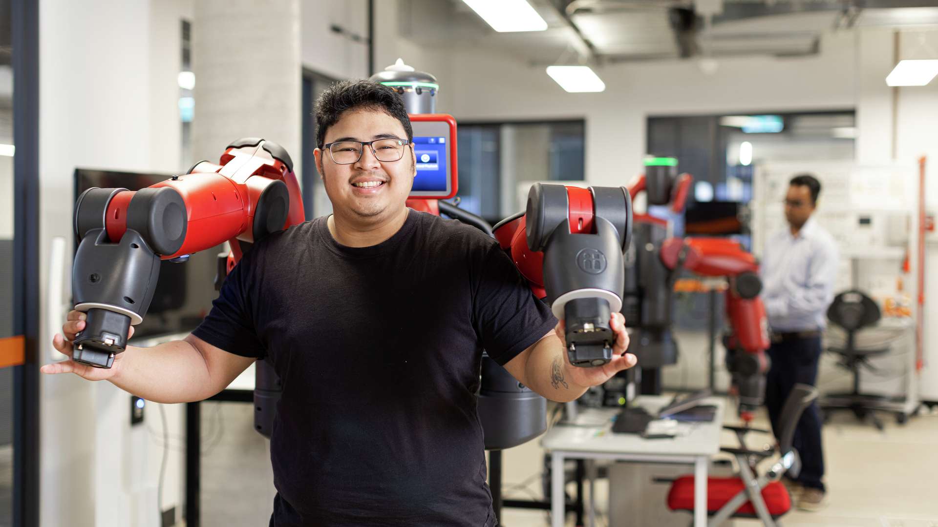 An engineering student experimenting with a robot in a lab