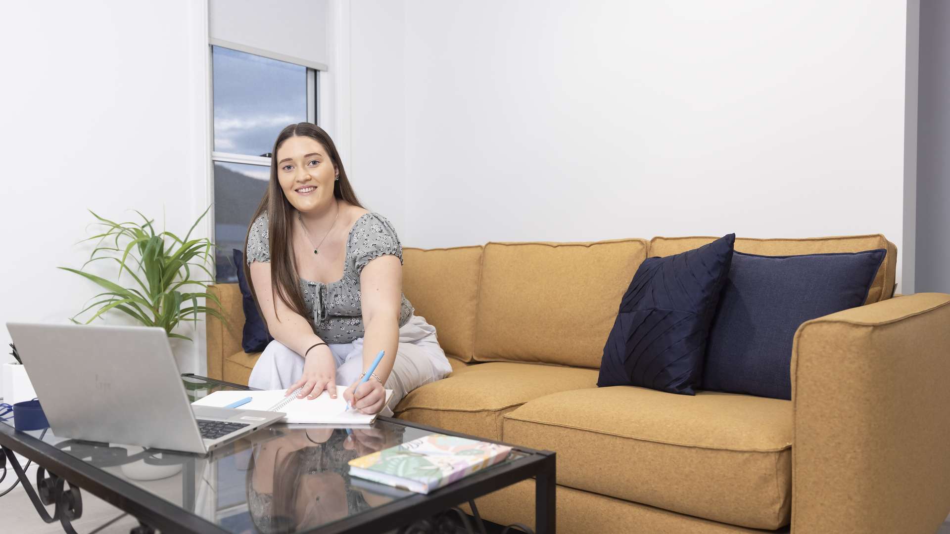 Lady studying on a lounge at home.