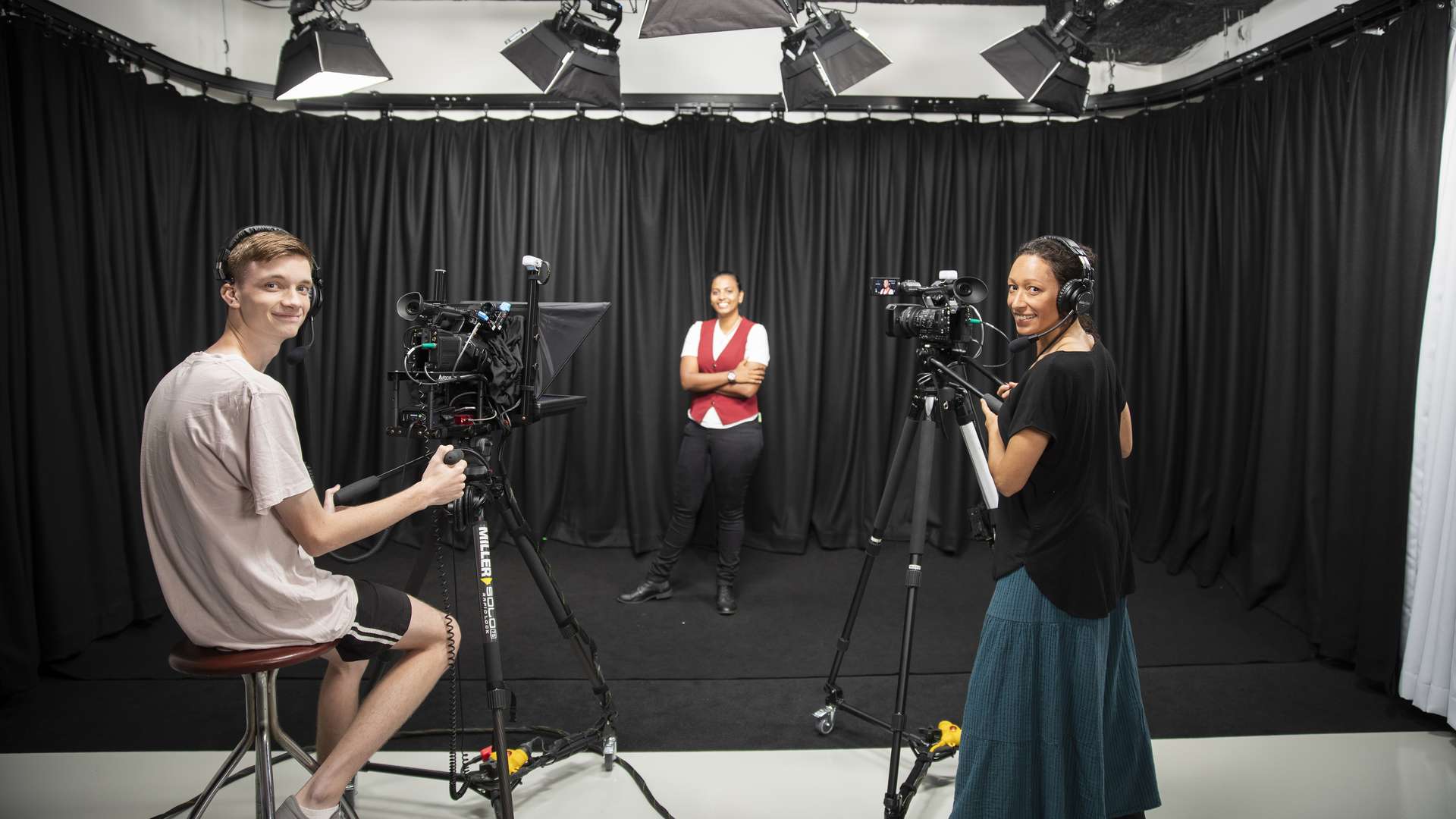 Two digital media students preparing to film someone in a studio.