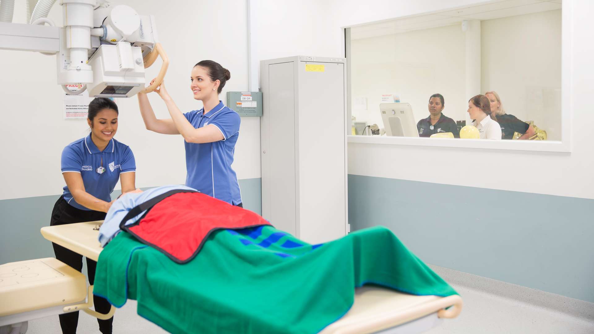 Medical Imaging Students using a large medical device on a patient