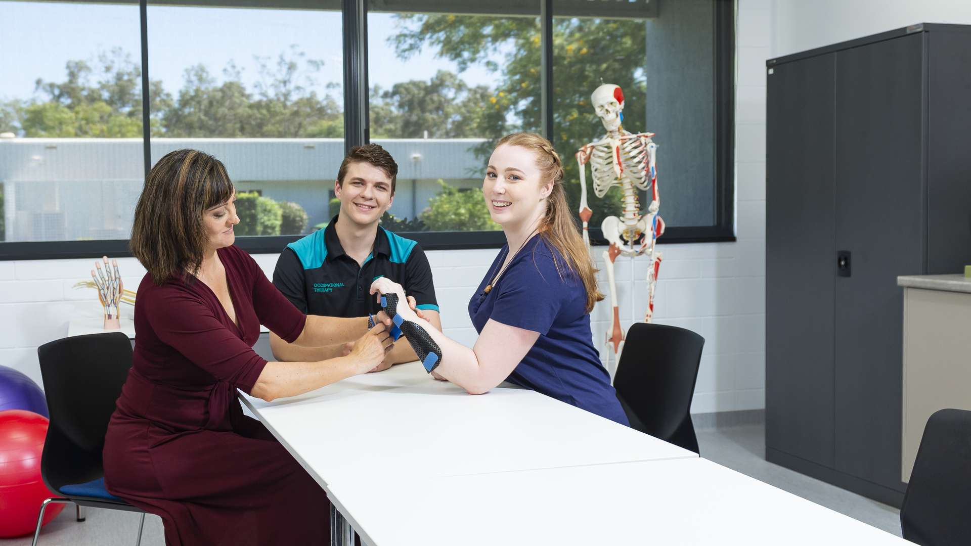 Occupational therapist placing a hand brace on an a student.