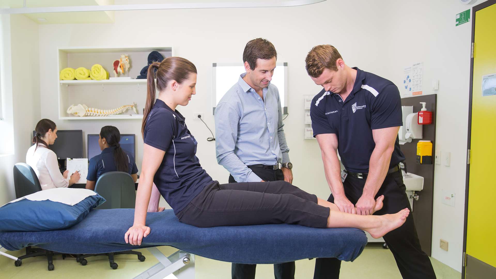 Physiotherapy Students practicing on each other, with the guidance of the teacher