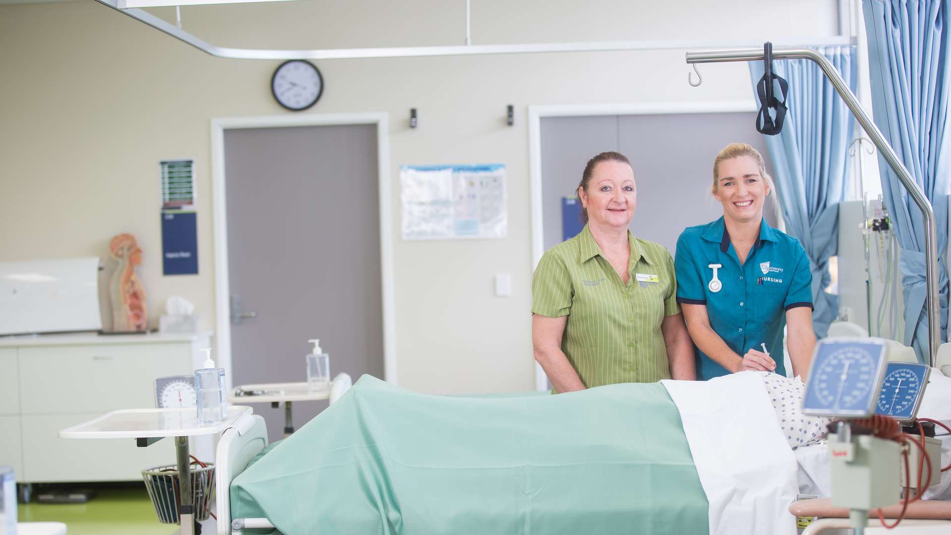 Nursing student practices in nursing lab with help from her lecturer