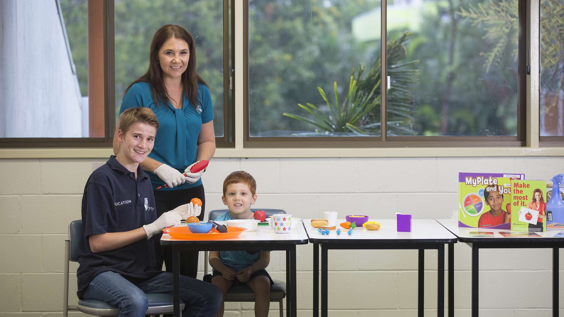 Early Childhood students teaching a child about good dietary habits.