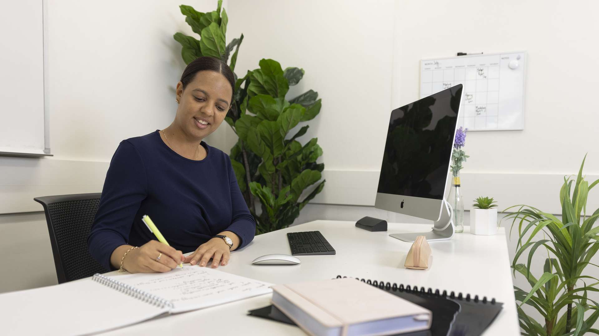 Lady working at a desk, writing in a notebook