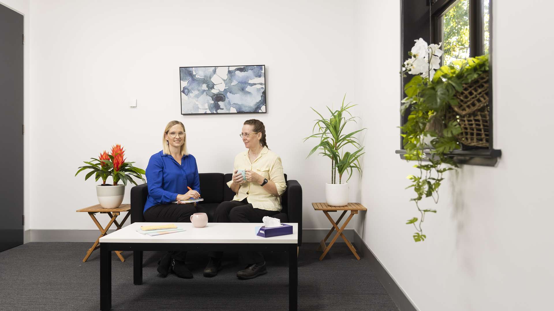 Counsellor meets with a patient on a couch in their office.