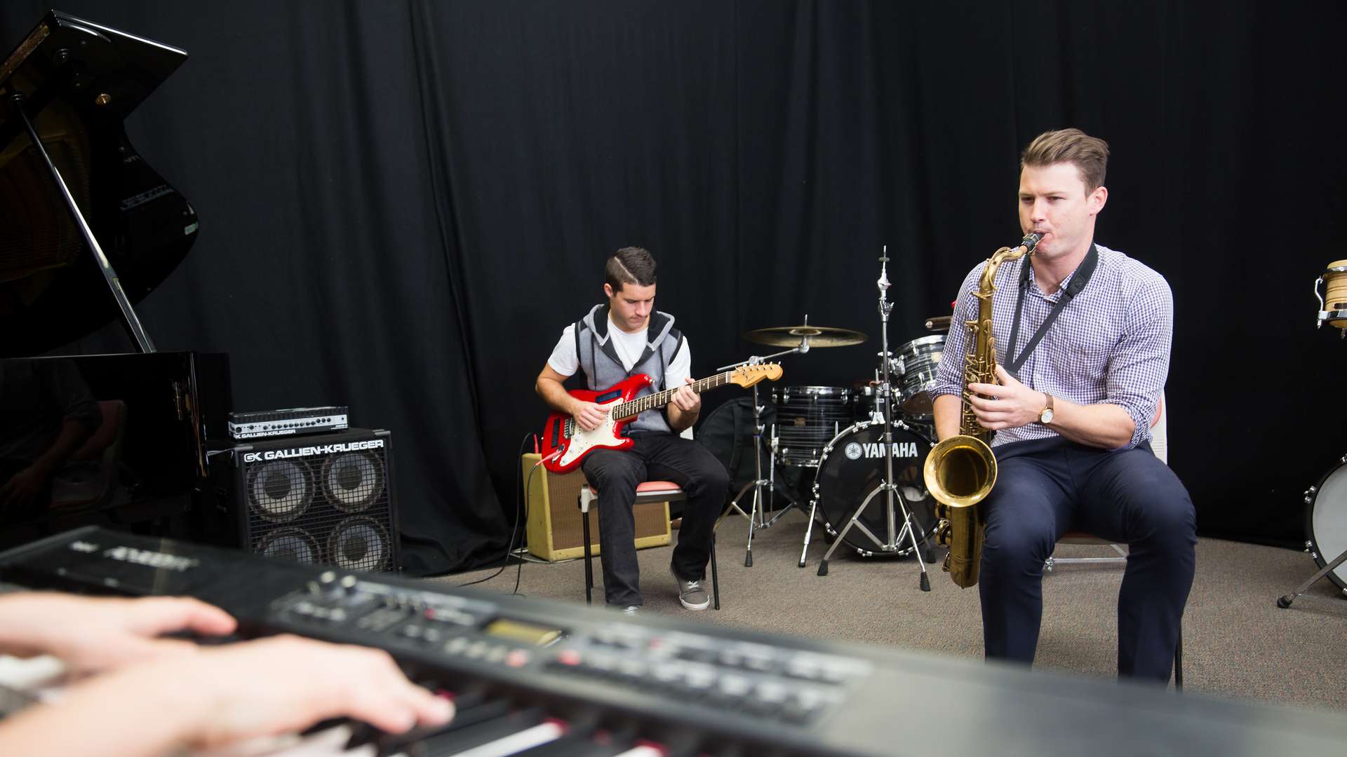 Music degree students in a studio practicing as a band