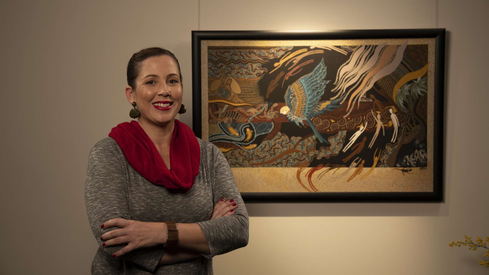 A person standing in front of a wall-mounted artwork.