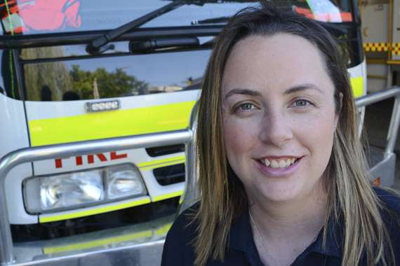 Dr Grace Vincent smiling in front of fire truck