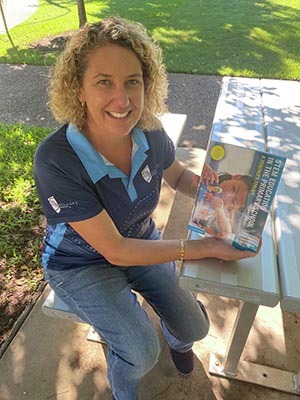 Dr Linda Pfeiffer holding a STEM Research textbook