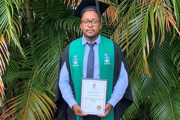 Epaphras Massawe holding his diploma