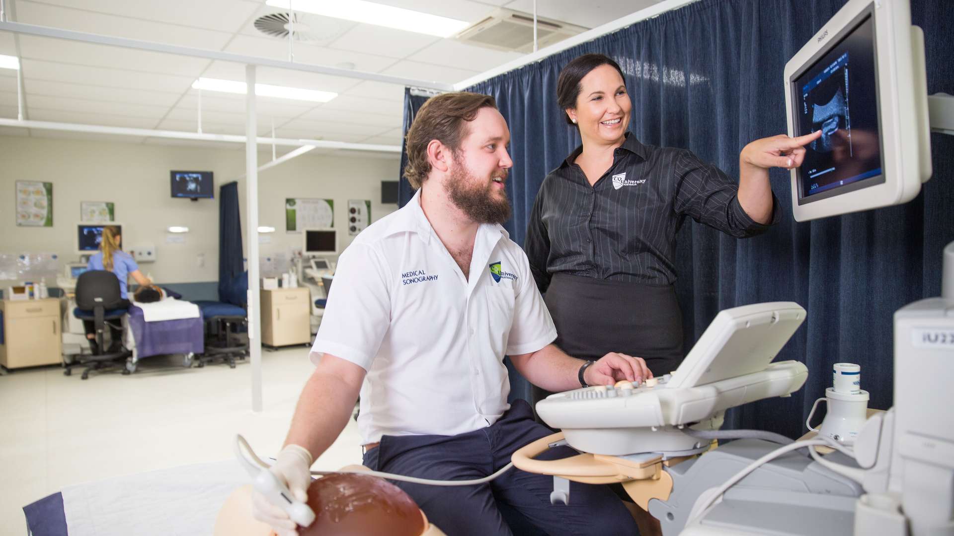 Instructor guiding student using a Sonography Machine