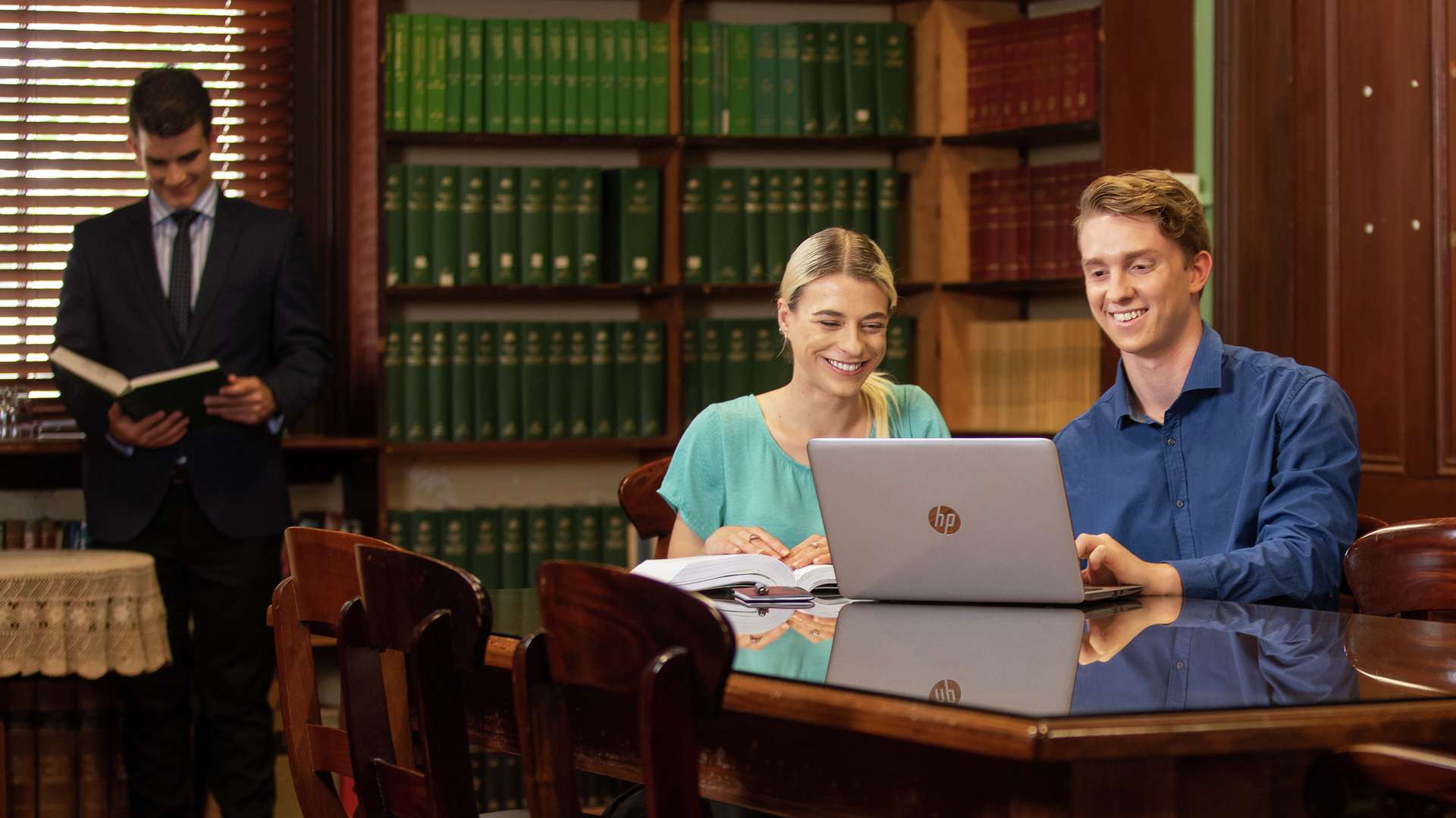 Students studying together with a laptop in a law library