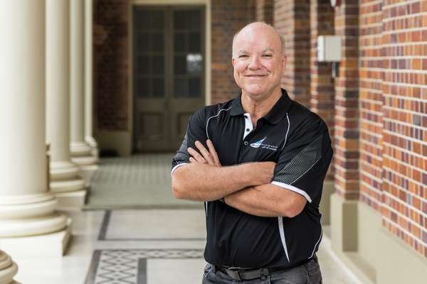 Tony George laughing with crossed arms