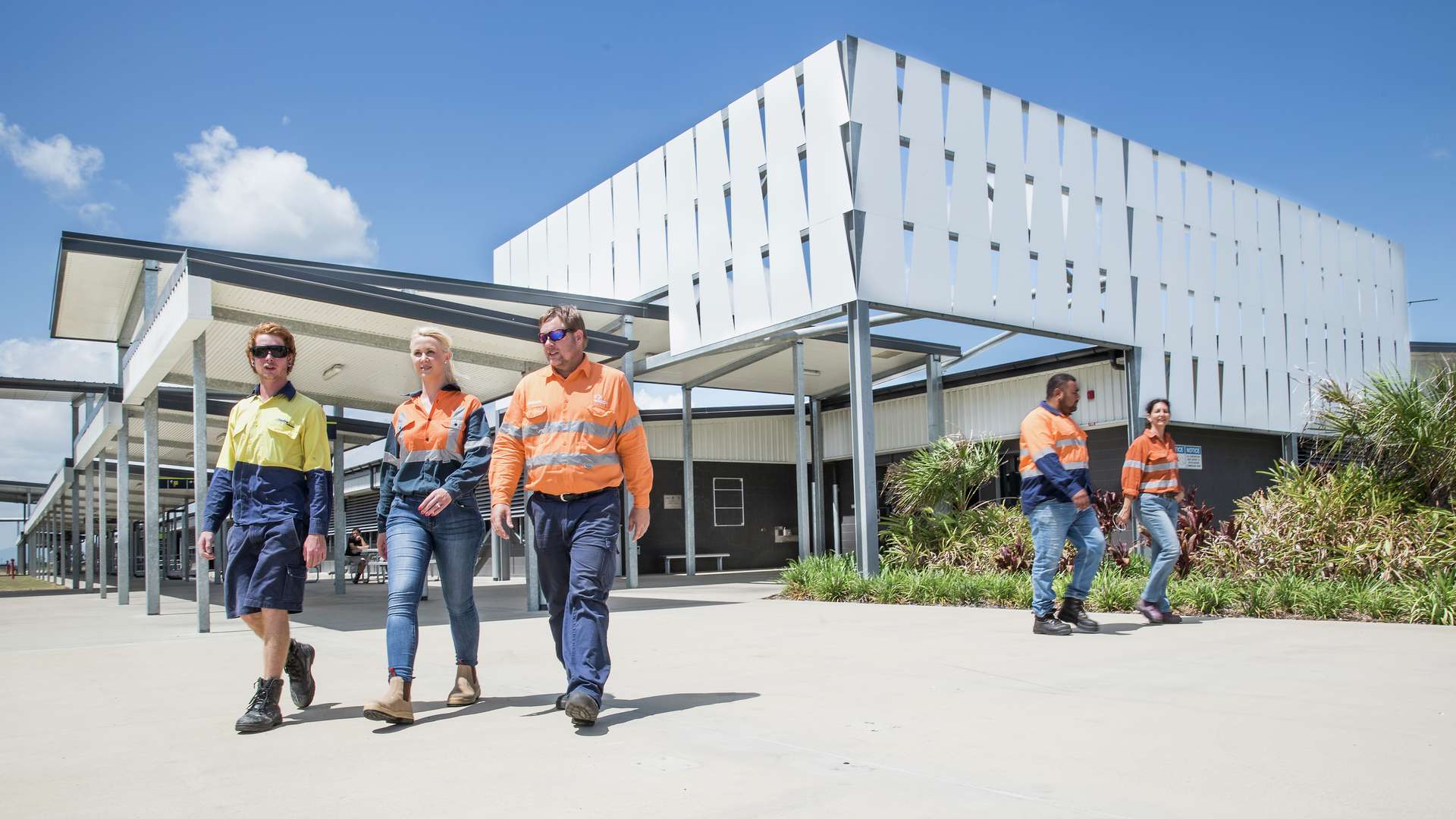 Trades students in hi-vis walking outside Mackay campus on a sunny day