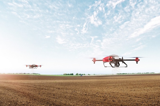 Two aerial drones flying over a farm