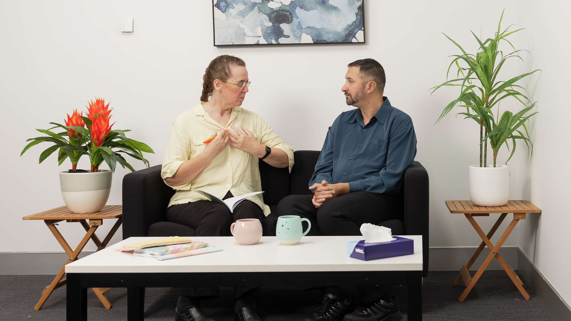 A counselling teacher working with a student in a therapy room