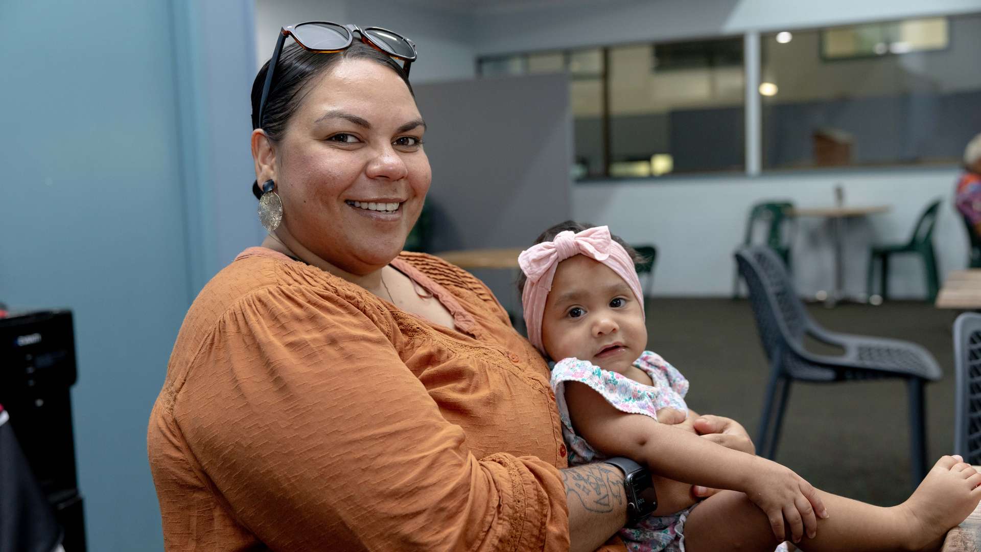 A person sitting holding a small child on their lap.