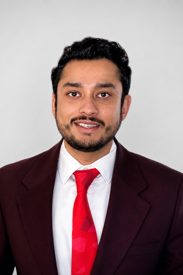 Alumnus Akshay Singh Vagle wearing a suit and red tie