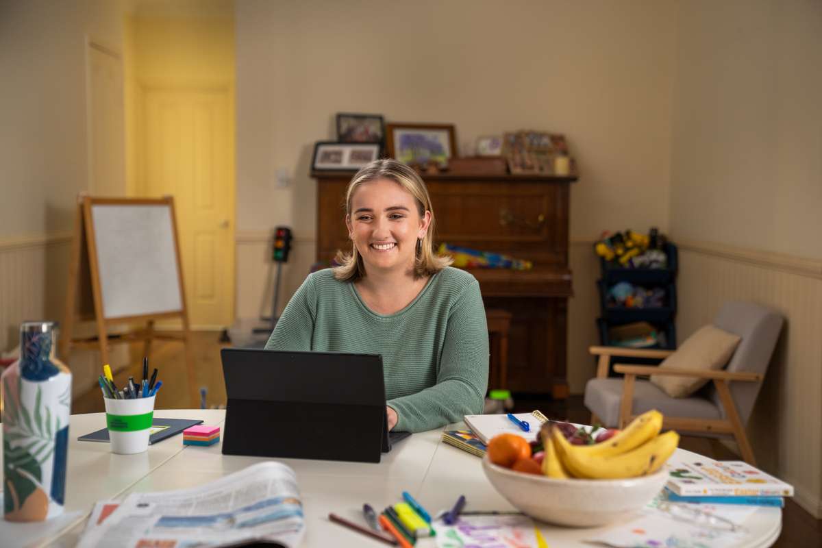 A woman studying at home on tablet computer in her family home.