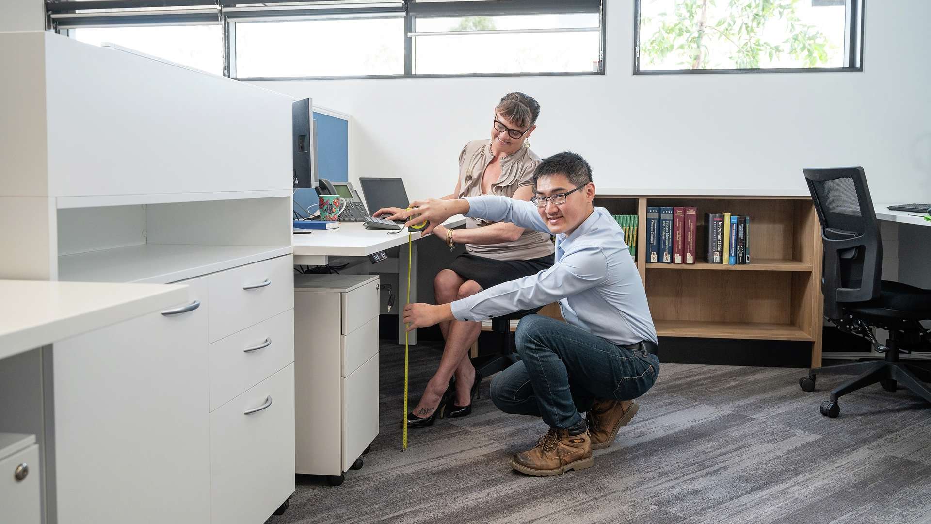 An officeworker measuring a desk