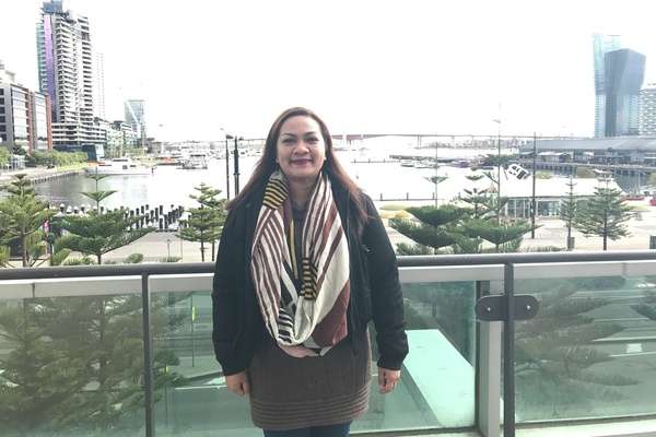 Annie Reyes smiling at the camera with Melbourne skyline in the background
