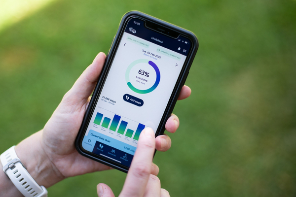 Hand holding a mobile phone that shows the 10,000 Steps app