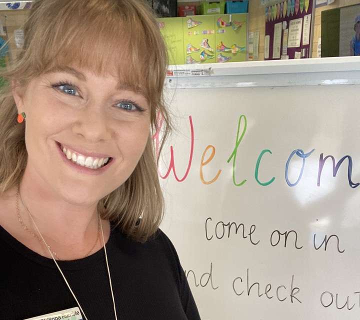 Philippa Rumble smiling with a classroom setting in the background