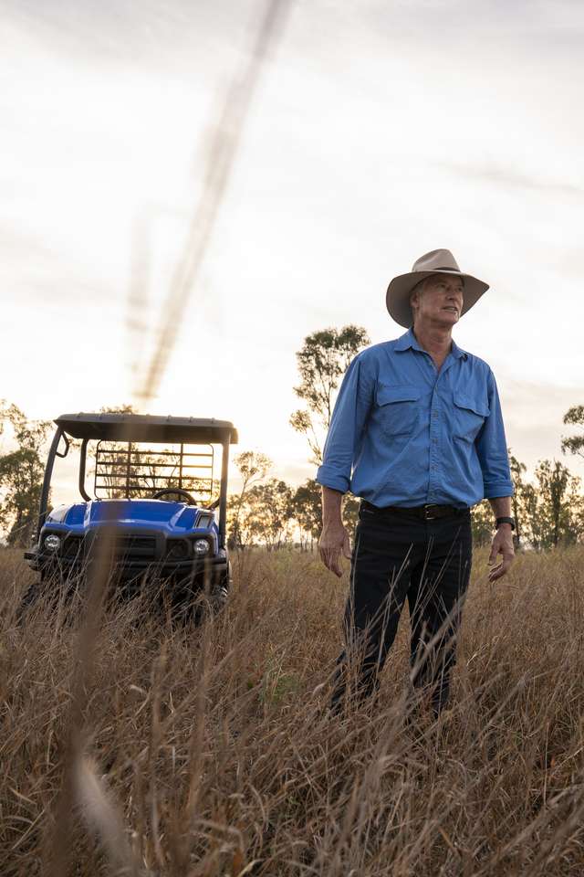 An agriculture student standing in open bushland