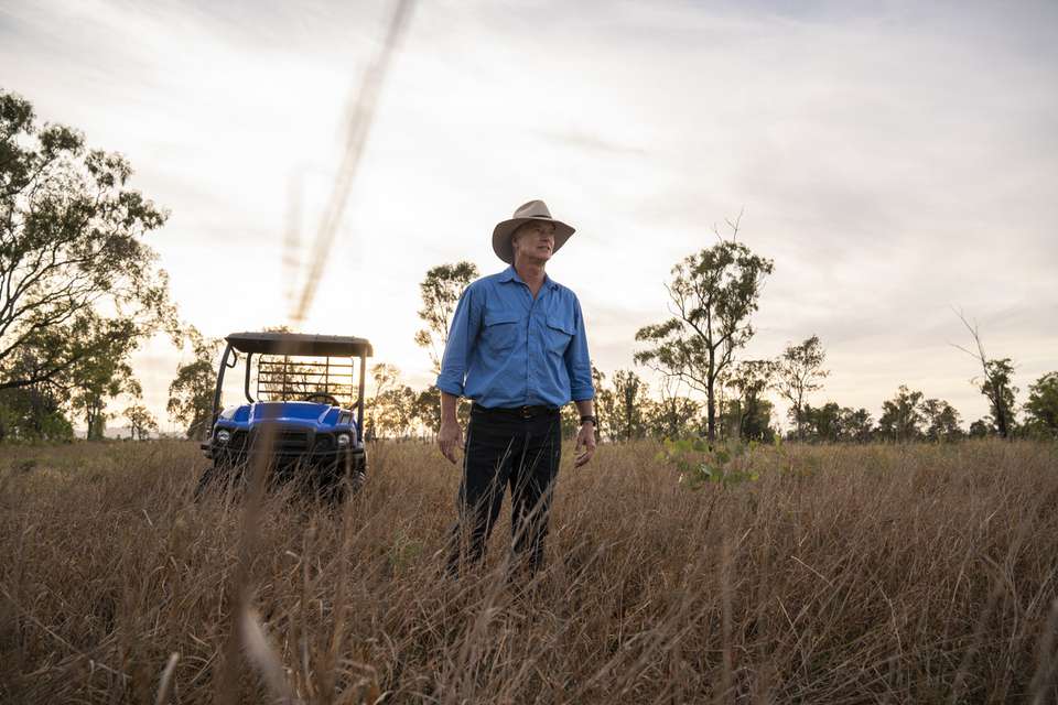 An agriculture student standing in open bushland