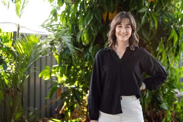 Tahlia Blanchfield standing in front of garden and trees smiling