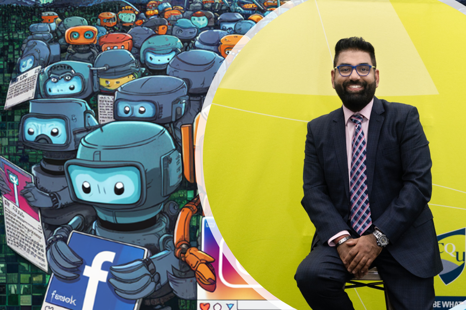 Ritesh sitting in front of a mural depicting small robots holding social media platforms signs