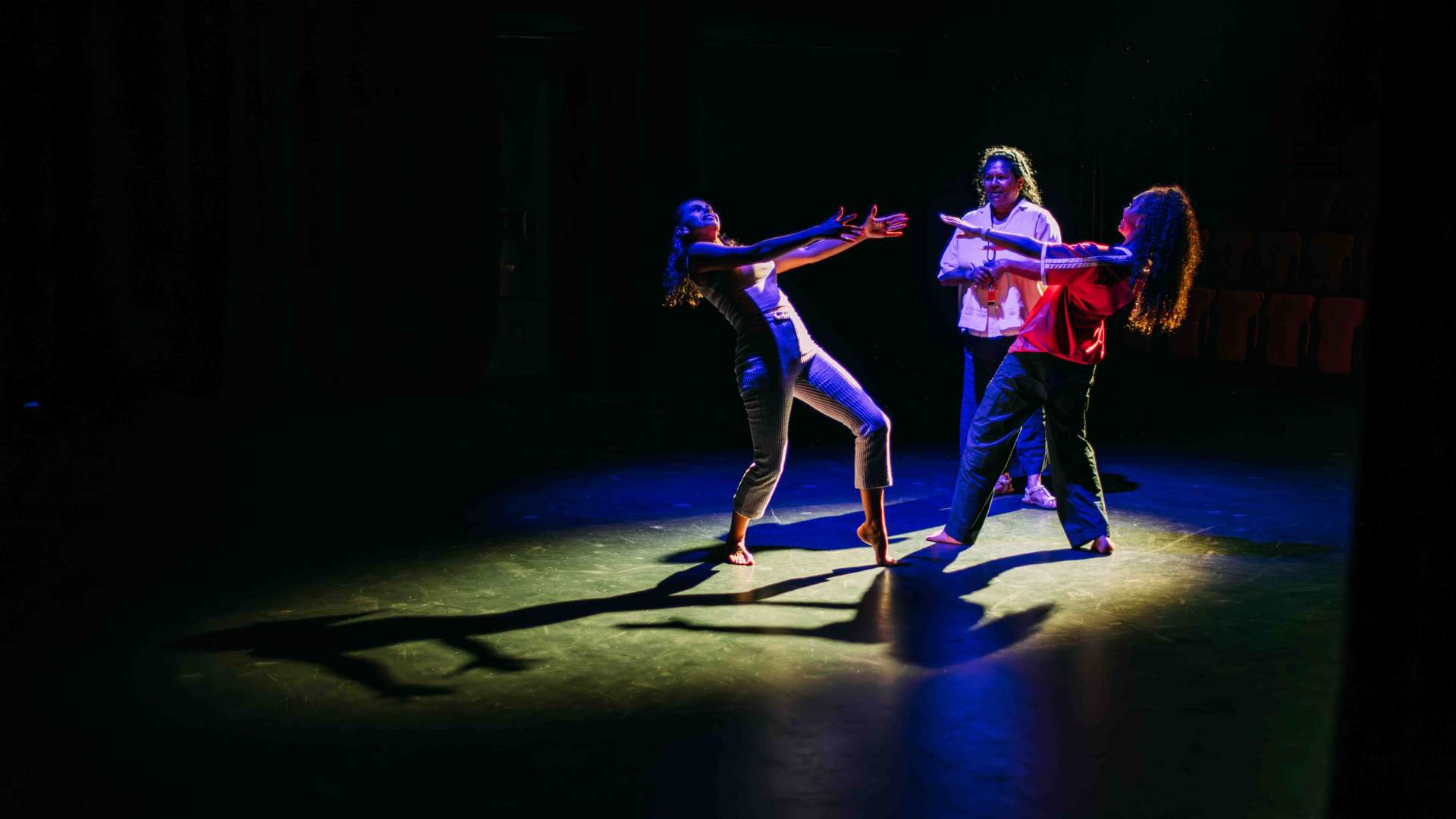 Binalmalmal students spotlighted on a stage dancing