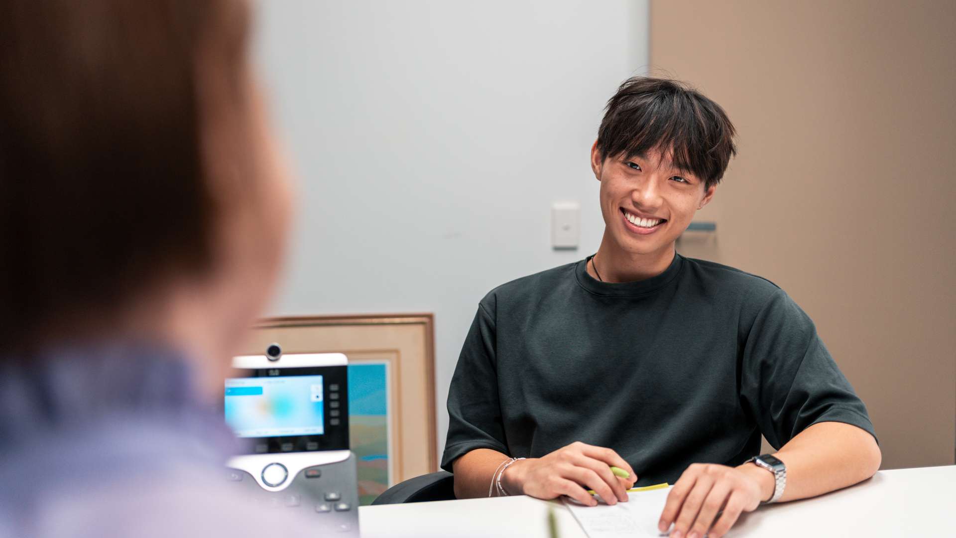 Young student with teacher in office