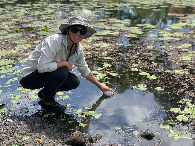 CMERC Researcher collecting water from a pond