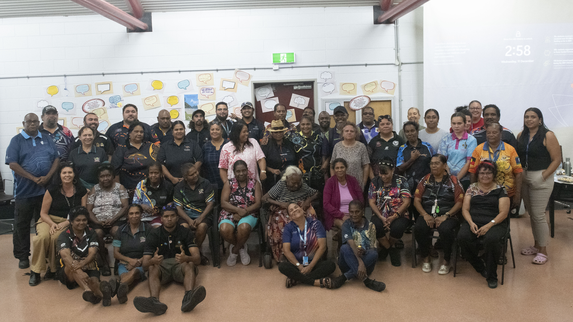 Large group of people posing together in a community hall