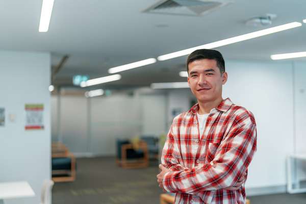 Daler Abdukarimov standing in a room with chairs in the background