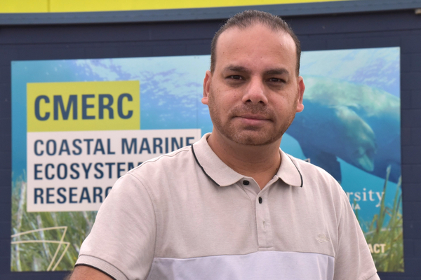 Dr Manoj Kumar standing in front of CMERC sign