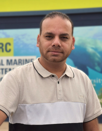 Dr Manoj Kumar standing in front of CMERC sign