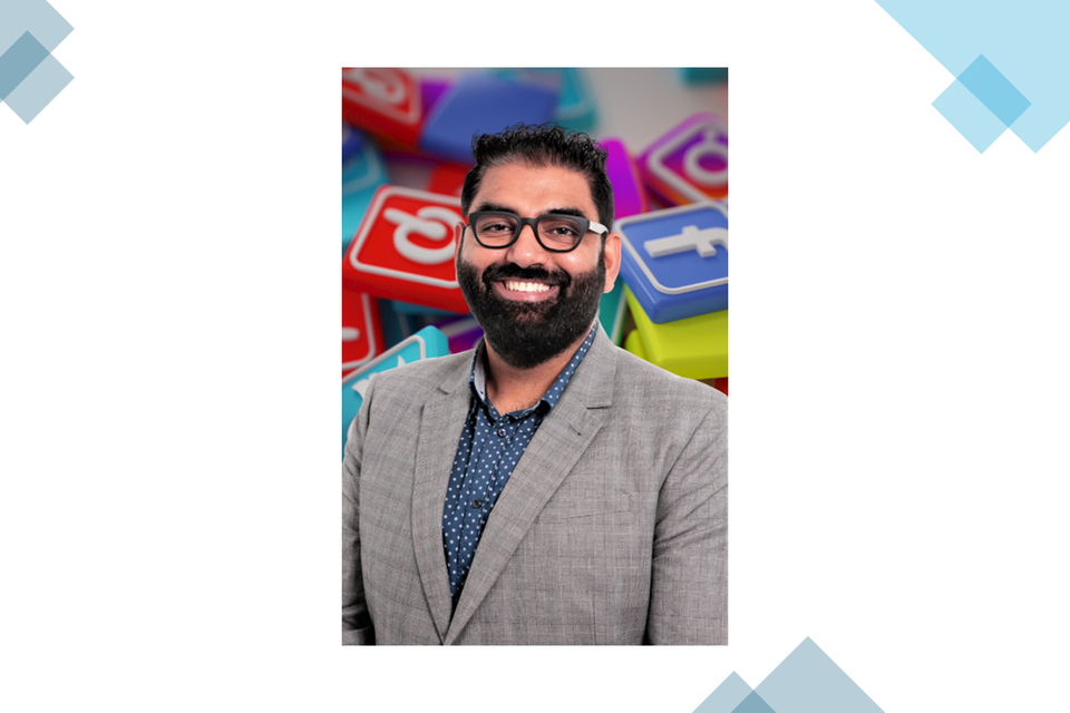 Ritesh smiling with a picture of social media logos behind him