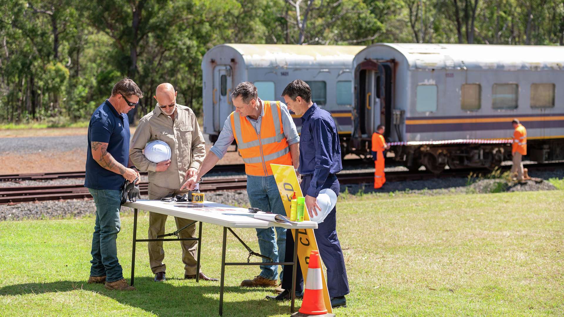 Emergency Disaster Management students strategising at a table in front of a trainline