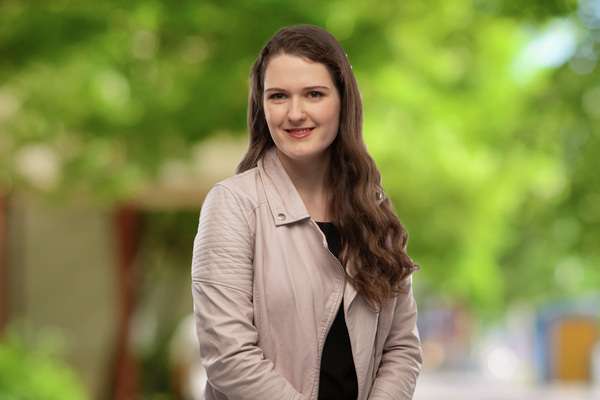 Emma Sutherland smiling bluer background