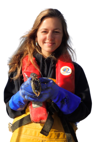 Emma Theobald in a life jacket holding a crab