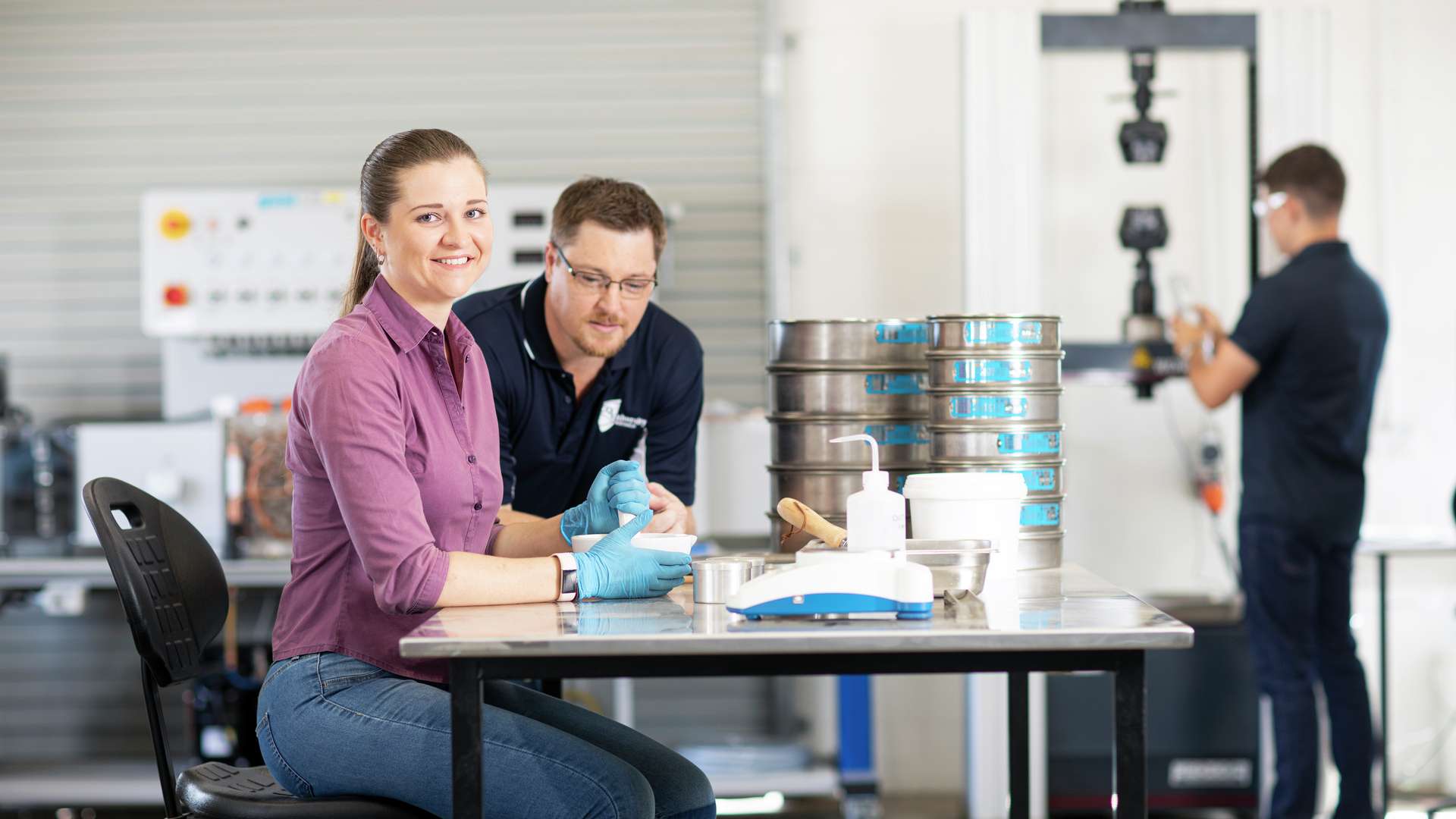 CQU engineering students with lecturer using lab equipment.