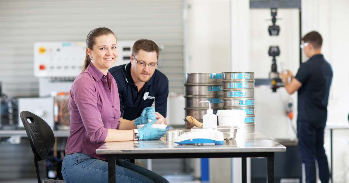 CQU engineering students with lecturer using lab equipment.