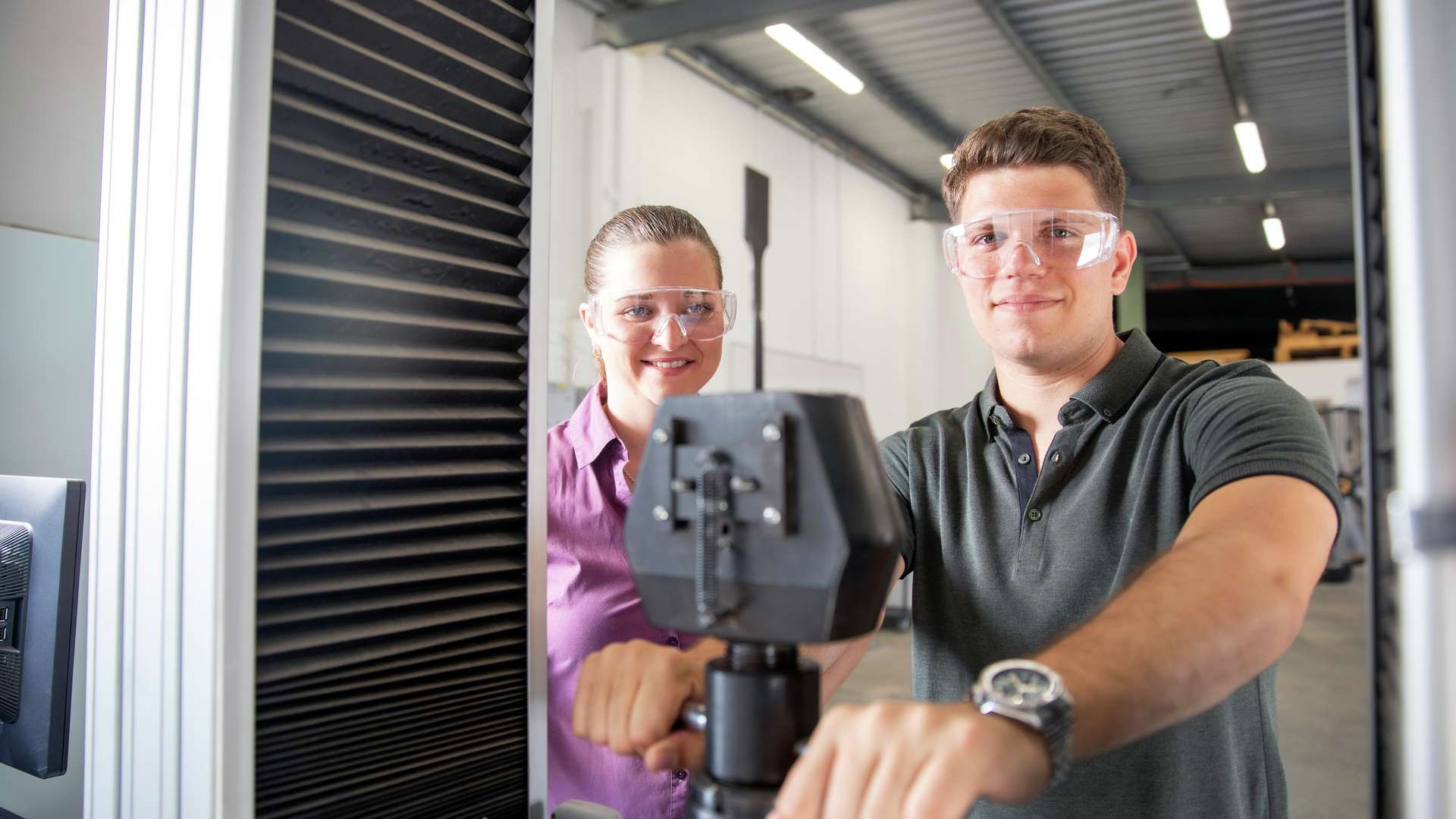 Engineering students wearing safety glasses as they use engineering equipment