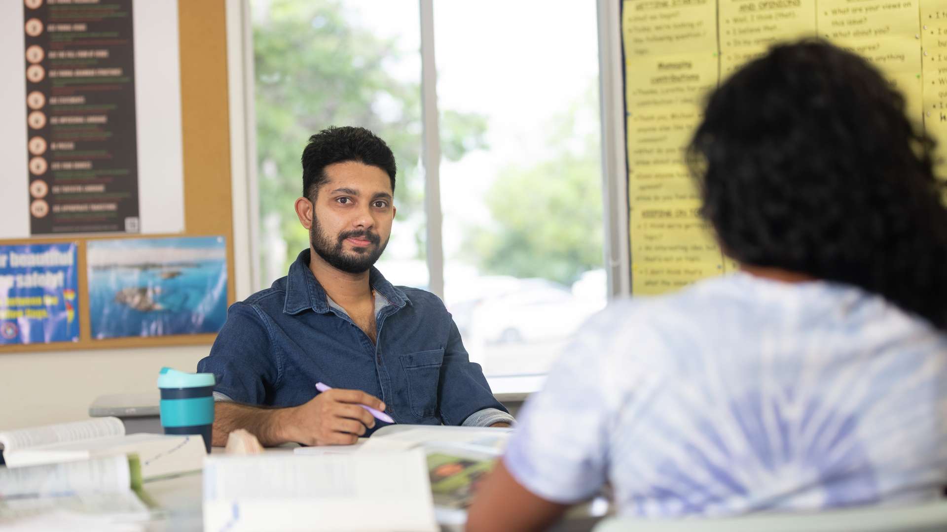 Two CQU English students studying, one looking at the camera whilst the other is facing away from the camera.