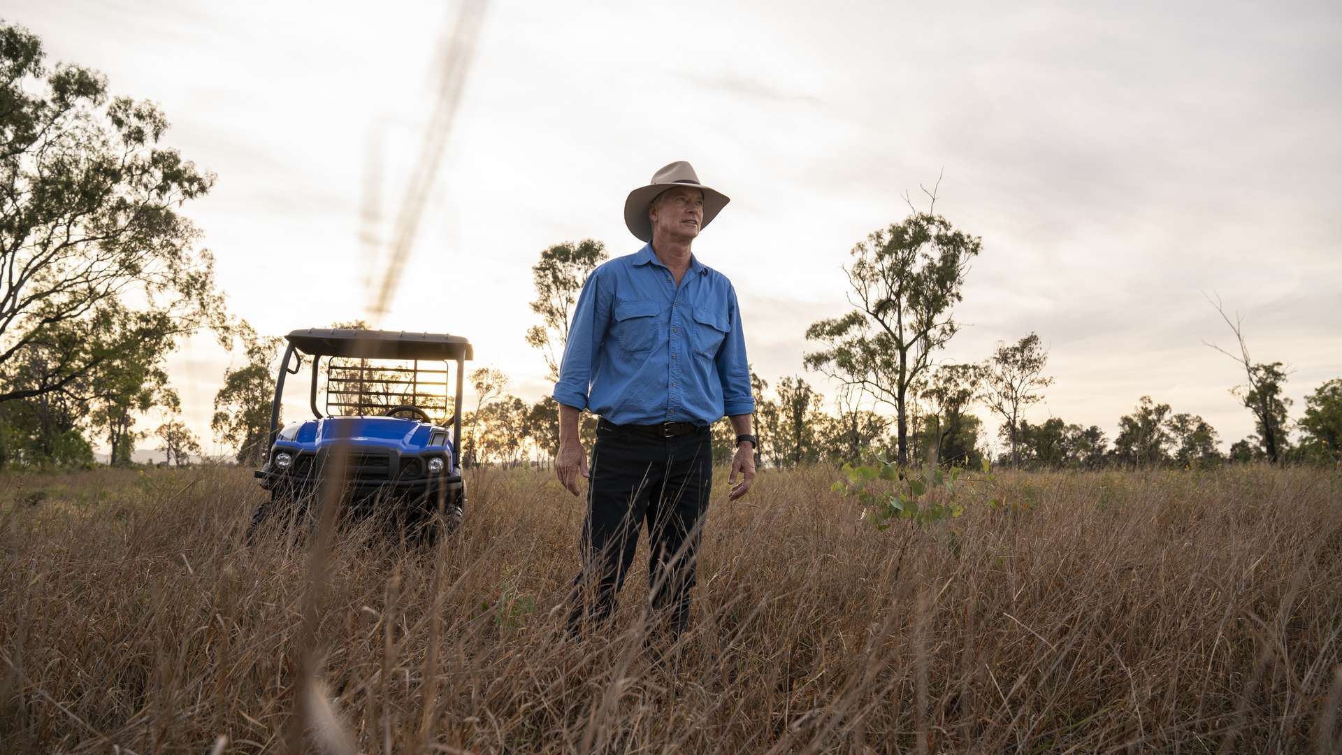 An agriculture student standing in open bushland